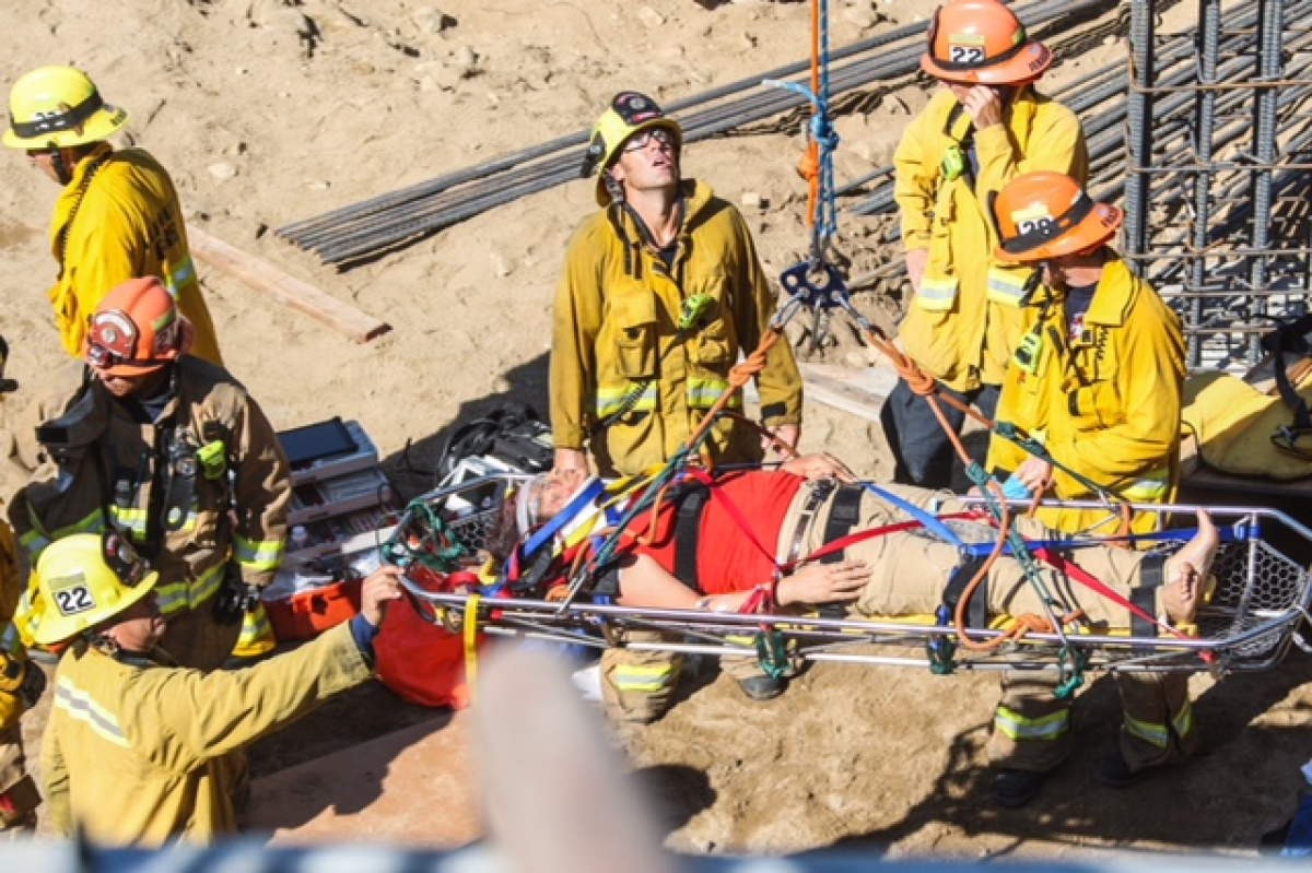 A woman who had crashed her car down into an excavated construction site is lifted to safety by Glendale firefighters on Thursday, Sept. 24, 2015.