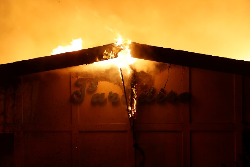 A burning sign is seen outside Paradise Skilled Nursing during the Camp fire in Paradise, Calif., on Nov. 8, 2018.