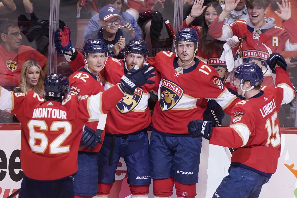 Florida Panthers teammates celebrate a goal by Florida Panthers left wing Mason Marchment (17) during the second period of Game 2 of an NHL hockey first-round playoff series , Thursday, May 5, 2022, in Sunrise, Fla. (AP Photo/Marta Lavandier)