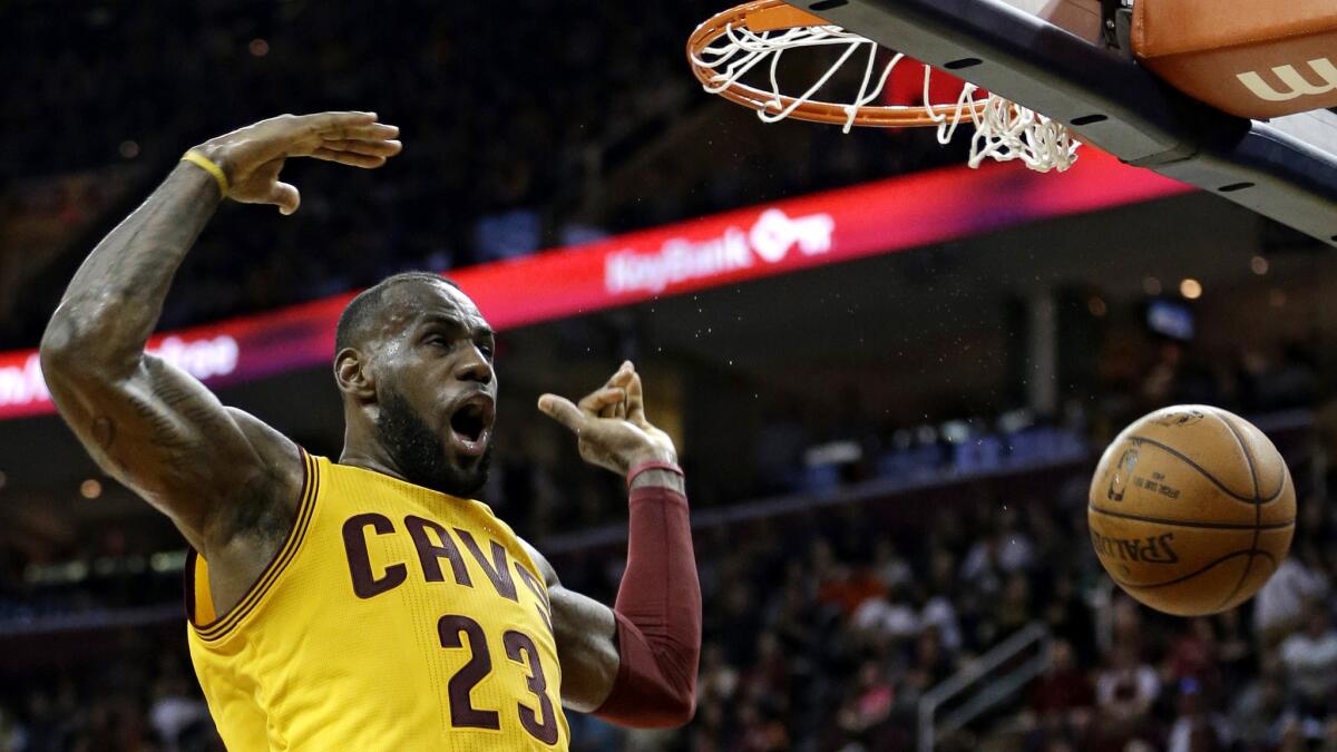 Cavaliers forward LeBron James reacts after dunking the ball against the Nets in the first half Thursday.
