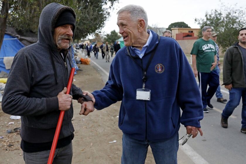 ANAHEIM, CALIF. -- WEDNESDAY, FEBRUARY 14, 2018: U.S. District Judge David Carter, right, greets Eddie S., 63, who is homeless, while surveying the homeless encampment along the Santa Ana River in Anaheim, Calif., on Feb. 14, 2018. Judge Carter ordered on Tuesday, Feb. 20, 2018 at 9:00 A.M. all persons living on the Santa Ana River between Ball Road/Taft Ave and Memory Lane must move out. Temporary motel rooms for a minimum of 30 days will be provided by the County of Orange. The County will clear the county's largest homeless encampment where several hundred people now live. (Gary Coronado / Los Angeles Times)