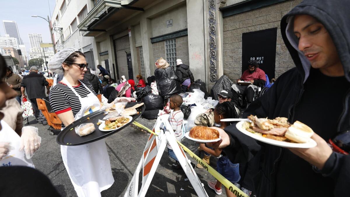 Homeless men, women and children gather on an L.A. street for a meal provided by Midnight Mission.