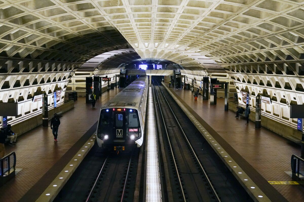 FILE - In this April 23, 2021 file photo, a train arrives at Metro Center station in Washington. Washington’s regional Metro system abruptly pulled more than half its fleet of trains from service early Monday morning over a lingering problem with the wheels and axles that caused a dramatic derailing last week. (AP Photo/Patrick Semansky)