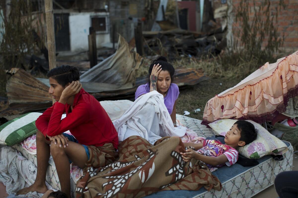 A family in Manta, Ecuador, wakes on April 19, 2016, after sleeping outside their home, which was destroyed by an earthquake.