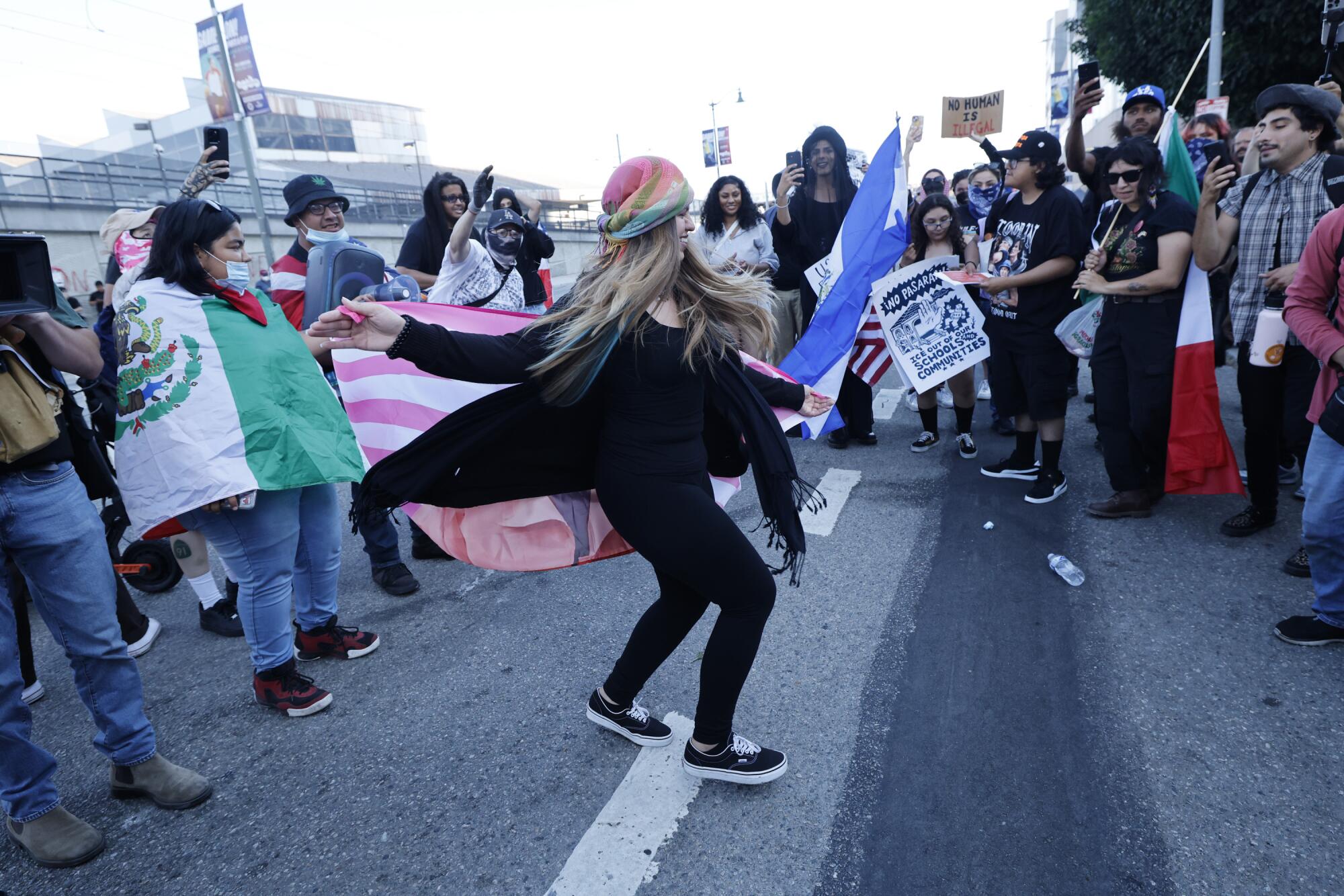 A woman dances in the middle of a circle during a rally in the street.