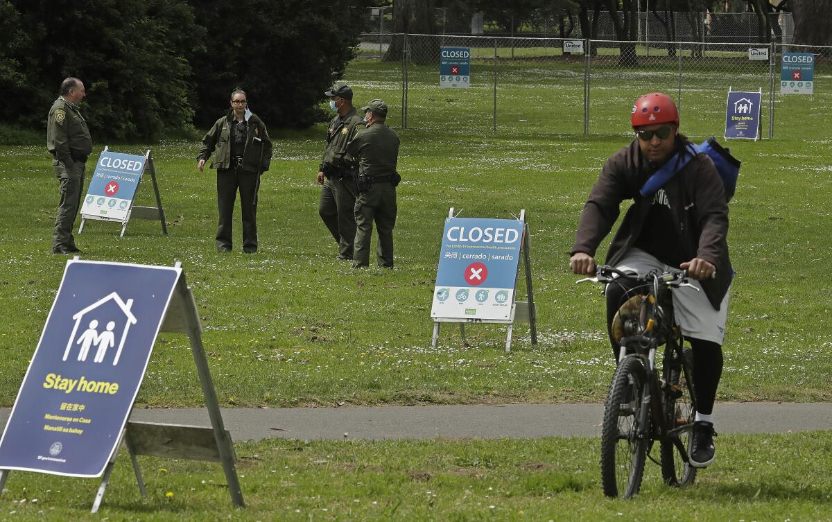 On a grassy lawn, signs are set up that say "Closed" and "Stay home."