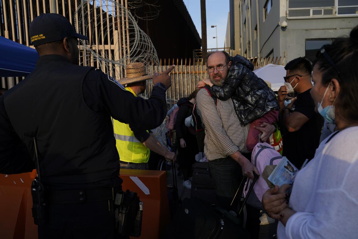 Ukrainian refugees speak with a United States Customs and Border Patrol official.