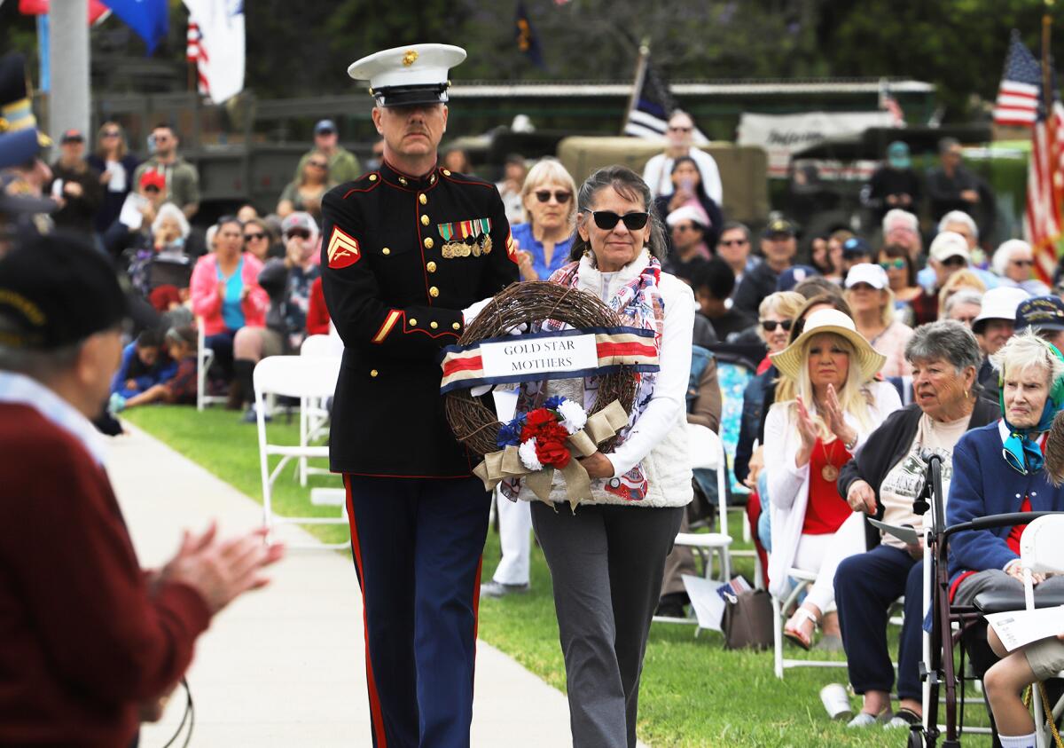 Dwight Hanson of the U.S. Marine Corps, left, escorts Maria Simpson.