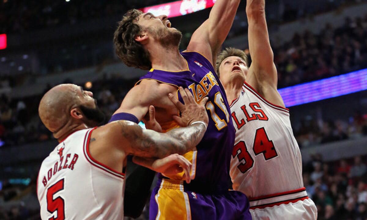 Lakers center Pau Gasol, middle, battles Chicago Bulls teammates Carlos Boozer, left, and Mike Dunleavy during the first half of the Lakers' 102-100 overtime loss Monday.