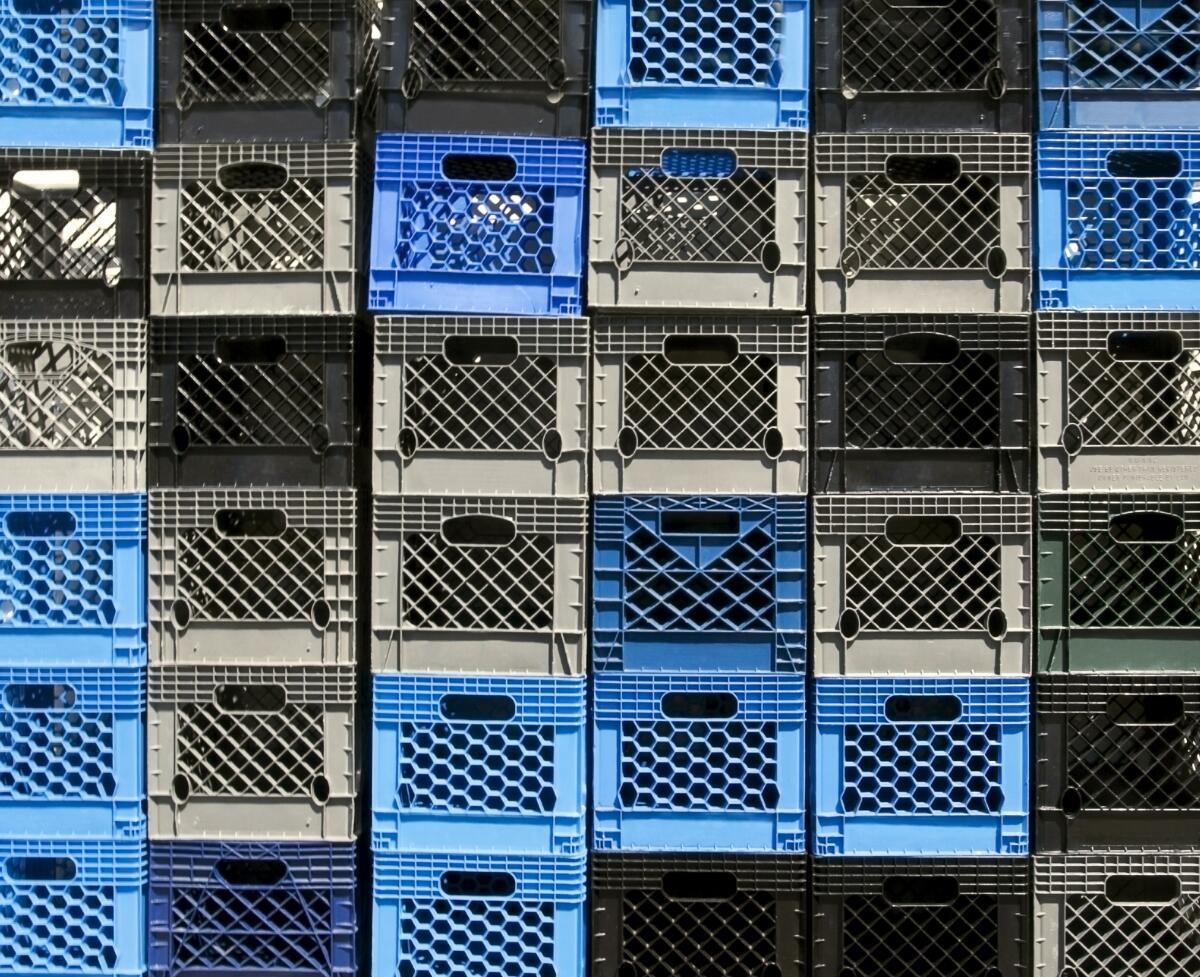 A massive stack of blue, black and gray plastic milk crates