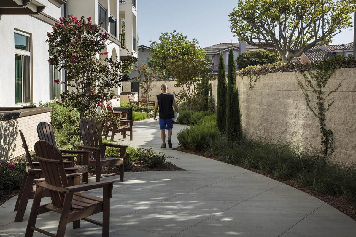 A resident veteran passes through the Heroes Landing reflection walk.