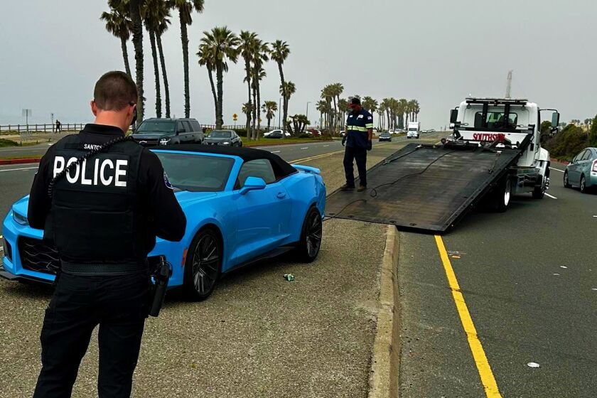Police tow a "Rapid Blue" Chevrolet Camaro Monday that was involved in a multi-agency police pursuit that ended on the PCH.