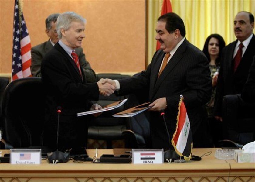 U.S. Ambassador to Iraq, Ryan Crocker, left, and Iraqi Foreign Minister Hoshyar Zebari, right, shake hands after a signing ceremony for a security pact between the United States and Iraq in Baghdad on Monday, Nov. 17, 2008. The U.S. ambassador says the Iraqi Cabinet's approval of a security pact extending the presence of American forces in Iraq for three years is "historic." The deal still needs parliamentary approval. (AP Photo/ Khalid Mohammed)