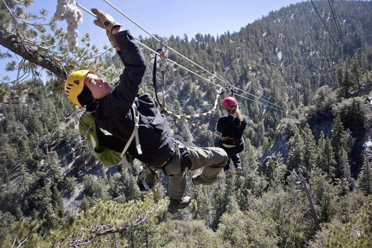 Tour guide Joel Hunt pulls in Jessica Pauline Ogilvie from a zip line in the San Bernardino National Forest.