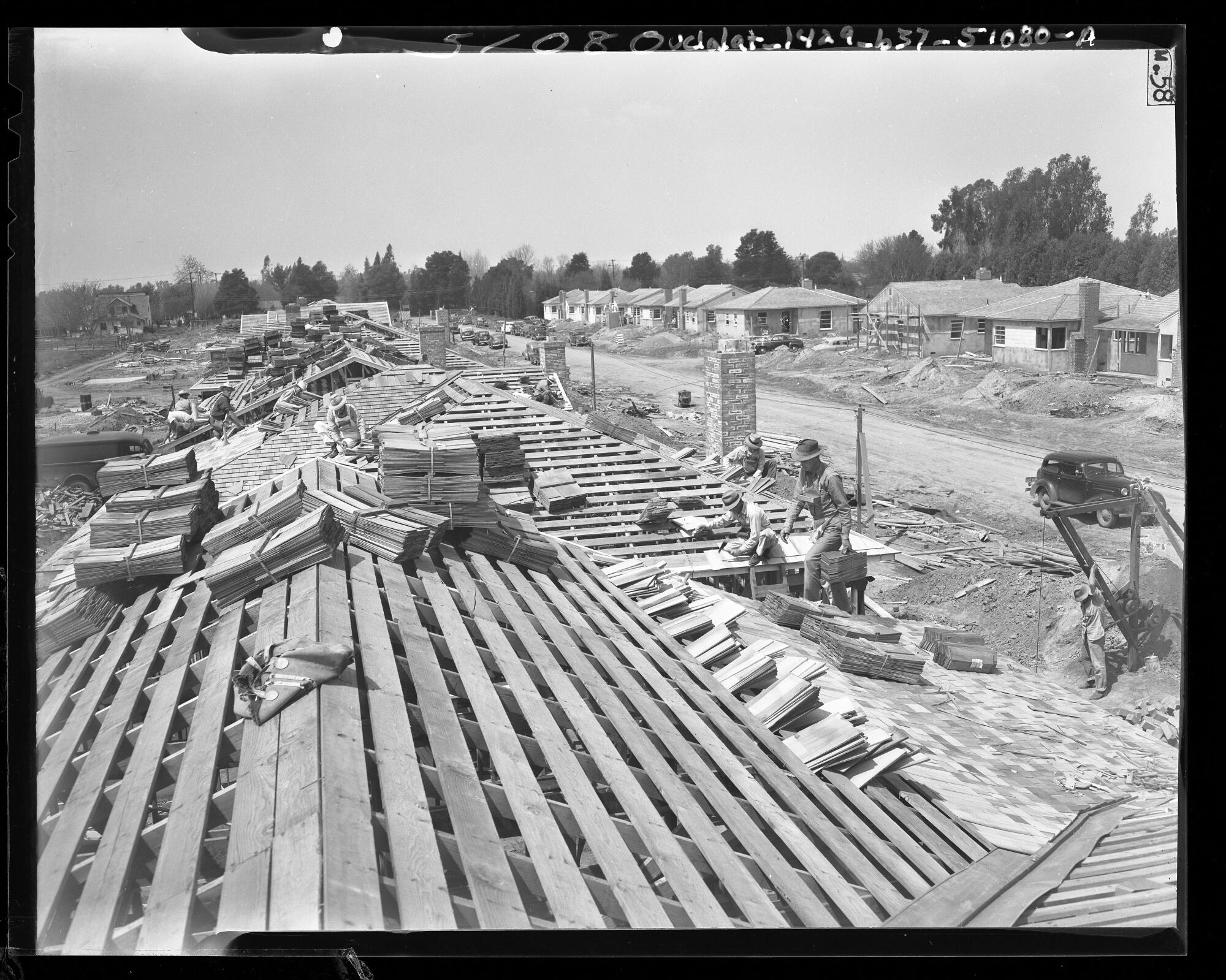 Workers put shingle roofs on new homes in a tract in Van Nuys on April 13, 1948.