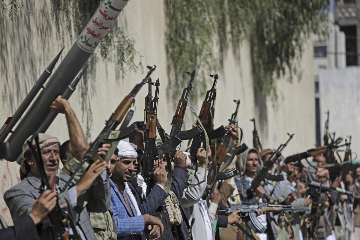 Yemeni tribesmen loyal to the Houthi rebel movement raise their weapons