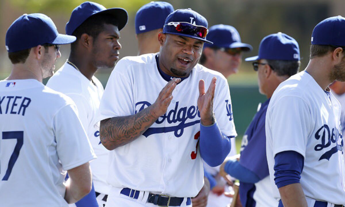 Dodgers outfielder Carl Crawford laughs with his teammates during a spring training session Friday. Crawford is staying positive heading into his second season with the Dodgers.