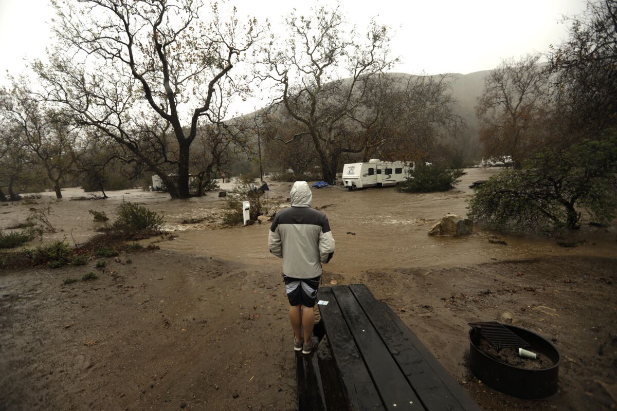 Keith Elvert, from Apple Valley, looks at his RV trailer surrounded by water as the creek overflows