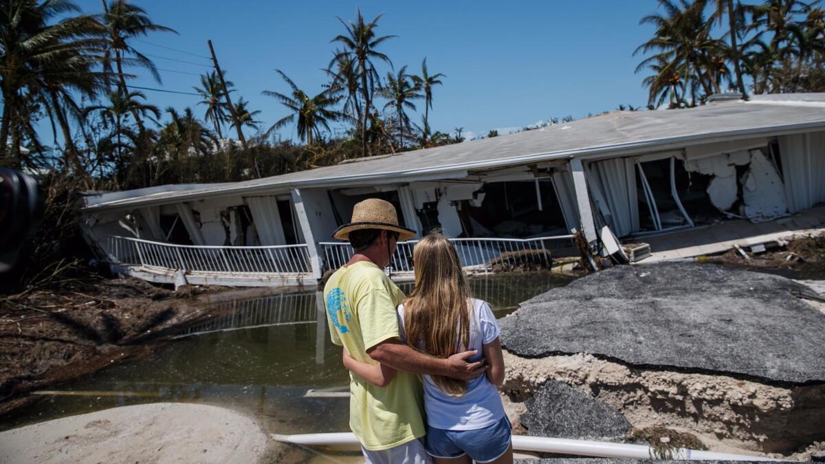 Brooke Gilbert, 15, and her father, Mike Gilbert, look at her grandparents' condominium building in Islamorada.