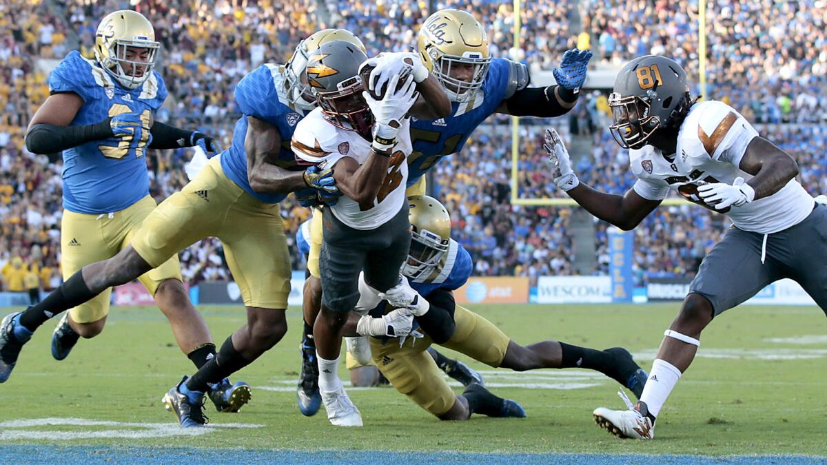 UCLA's defense can't prevent Arizona State receiver Tim White from scoring in the first quarter Saturday at the Rose Bowl.