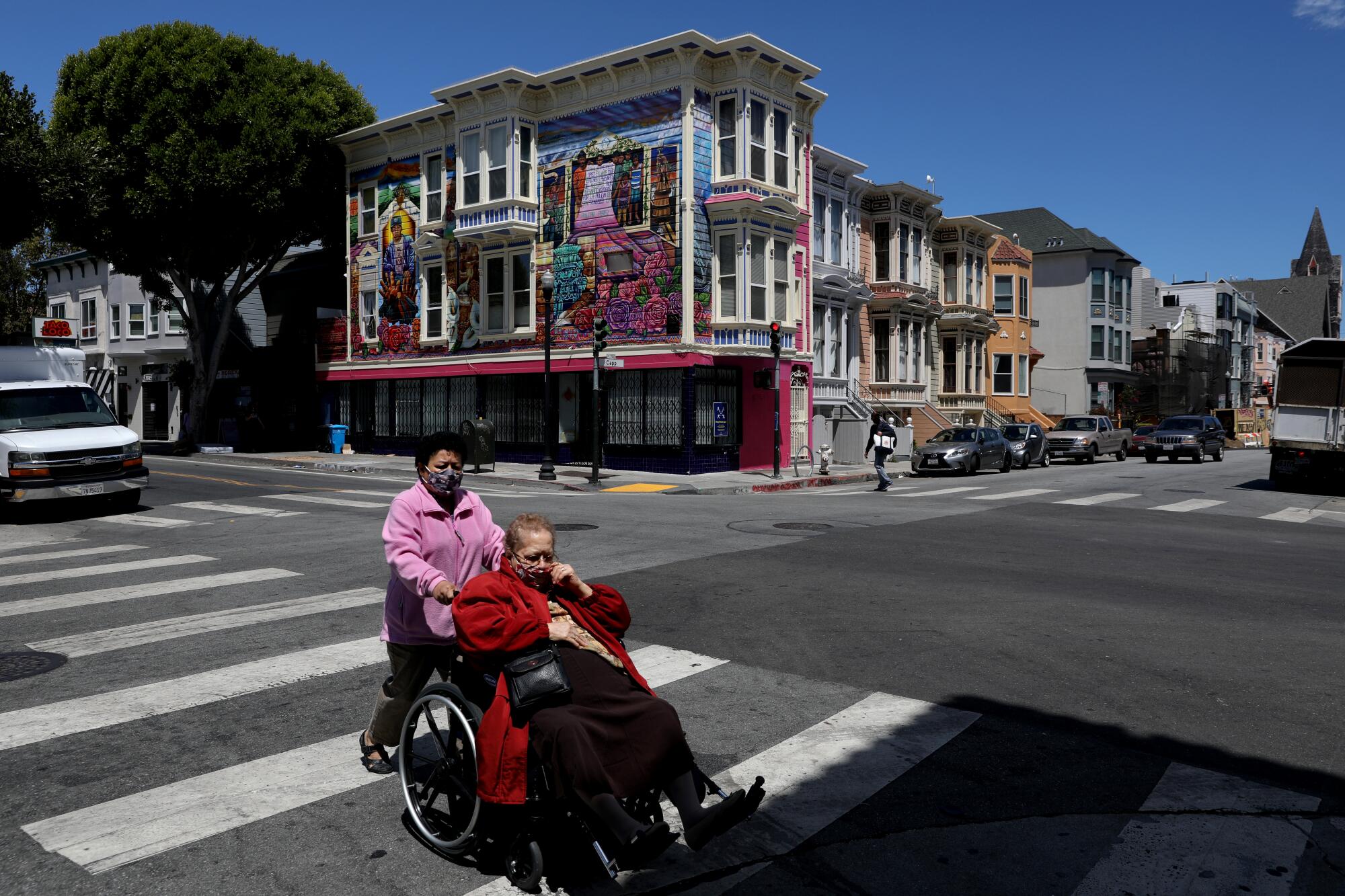 Pedestrians with face coverings along 24th Street in the Mission District.