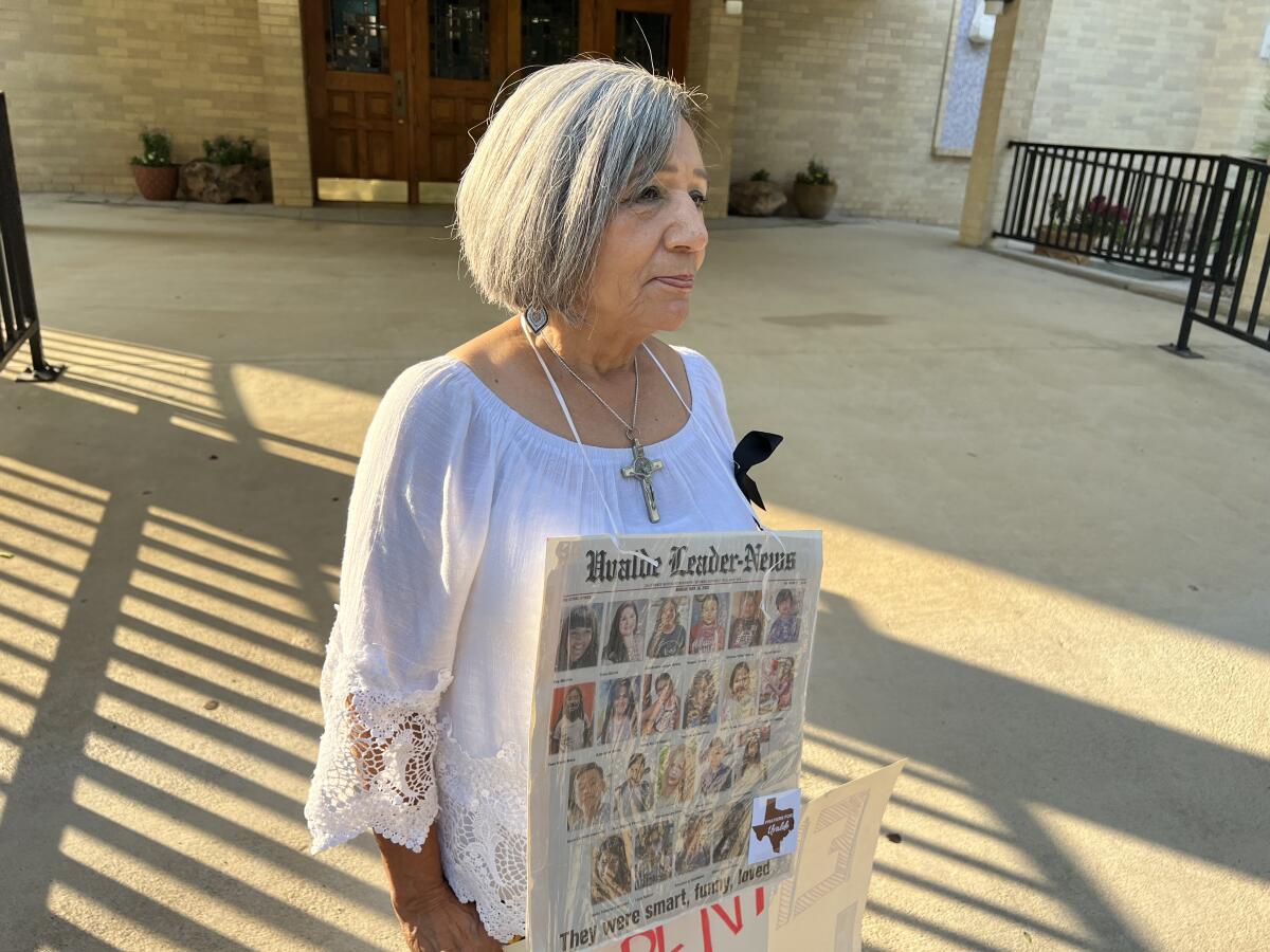 Woman wearing a sign showing photos of school shooting victims.