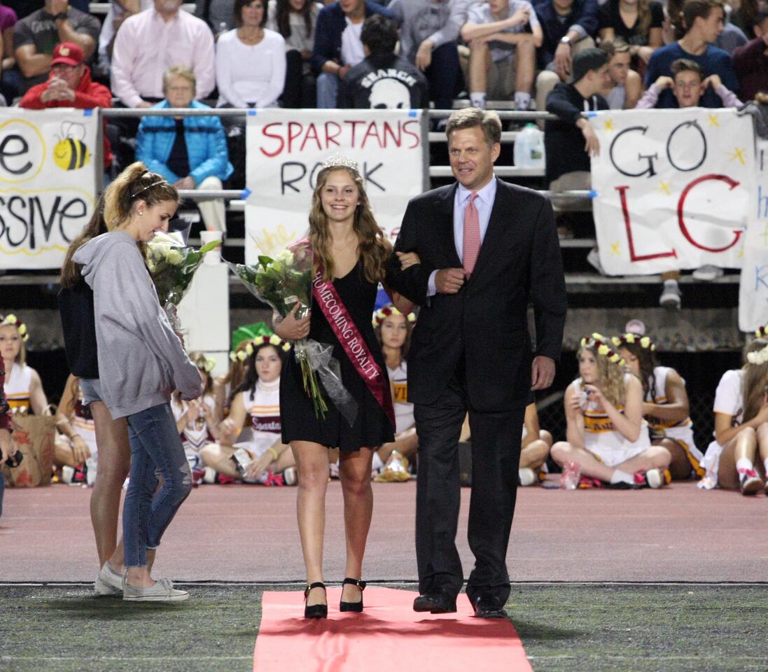 Homecoming court member Julia Harbolt is escorted by her father Tom during halftime at the La Cañada High School football game on Friday, Oct. 16, 2015.