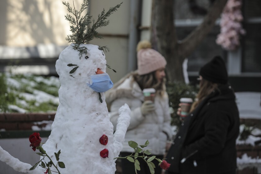 A snowman, featuring a mask, is seen in Istanbul, Monday, Jan 18, 2021. Snow blanketed most of the Turkish metropolis of some 16 million that spans two continents, bridging Europe to Asia and the flurries are forecasted to continue throughout the day. (AP Photo/Emrah Gurel)