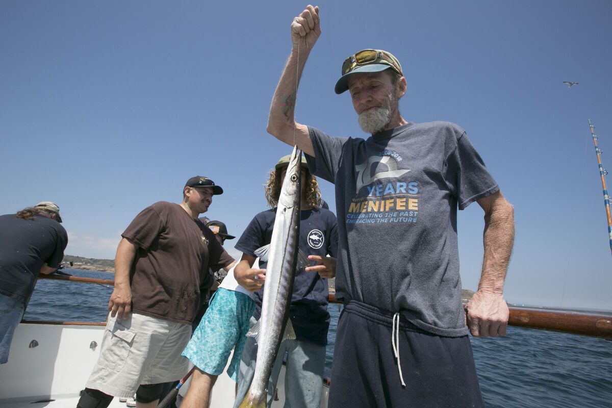 Army veteran Kelly Davolt admries a barracuda aboard the Fisherman III in June 2019.