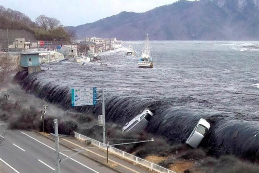 A tsunami wave breaches an embankment in the city of Miyako, Japan, on March 11.