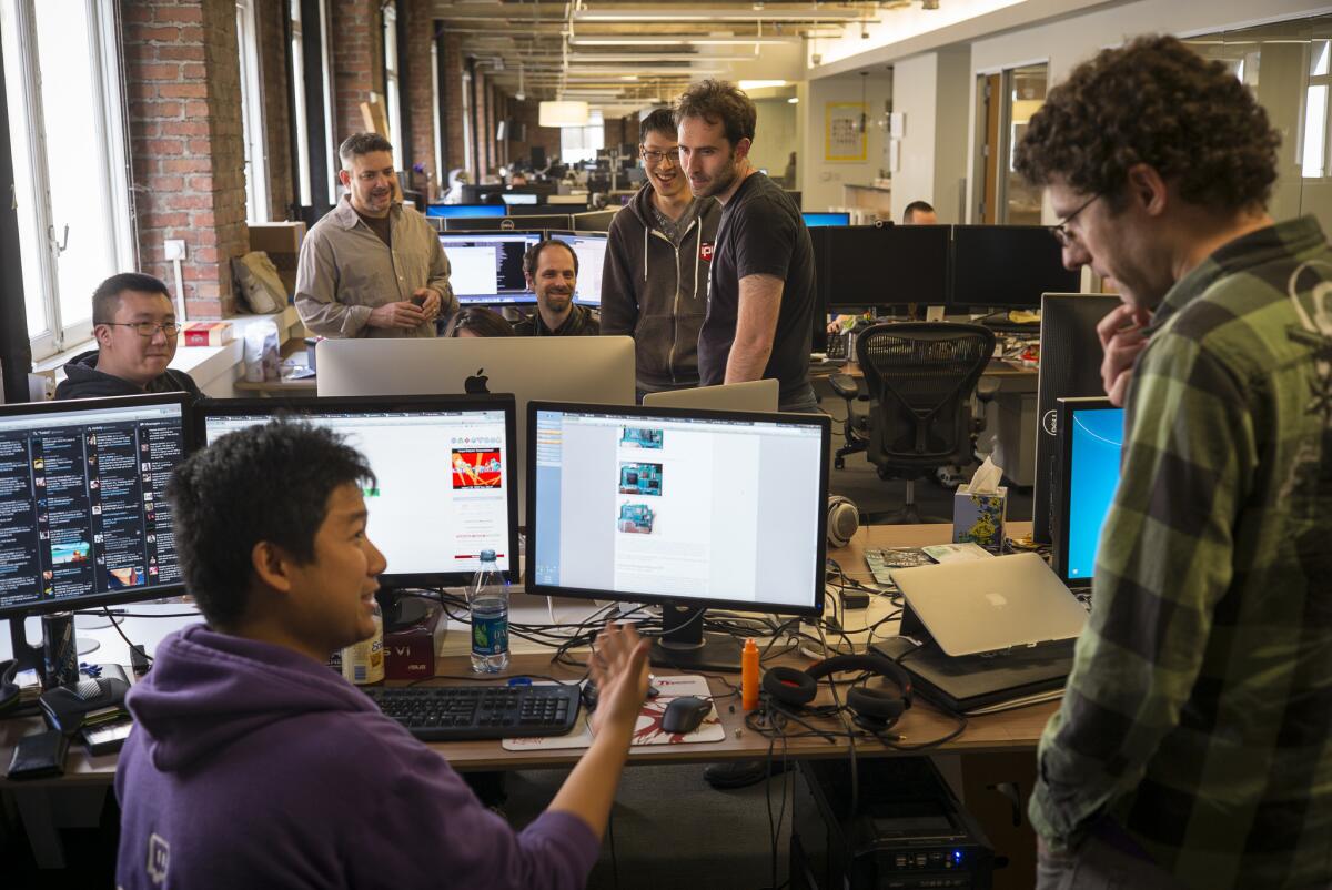 Emmett Shear, center in black t-shirt, talks with workers at the home offices of the internet company Twitch which allows online gamers to broadcast a live stream of themselves as they are playing. (David Butow/Los Angeles Times)