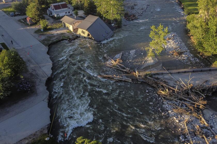 A house sits in Rock Creek after floodwaters washed away a road and a bridge in Red Lodge, Mont., Wednesday, June 15, 2022. (AP Photo/David Goldman)