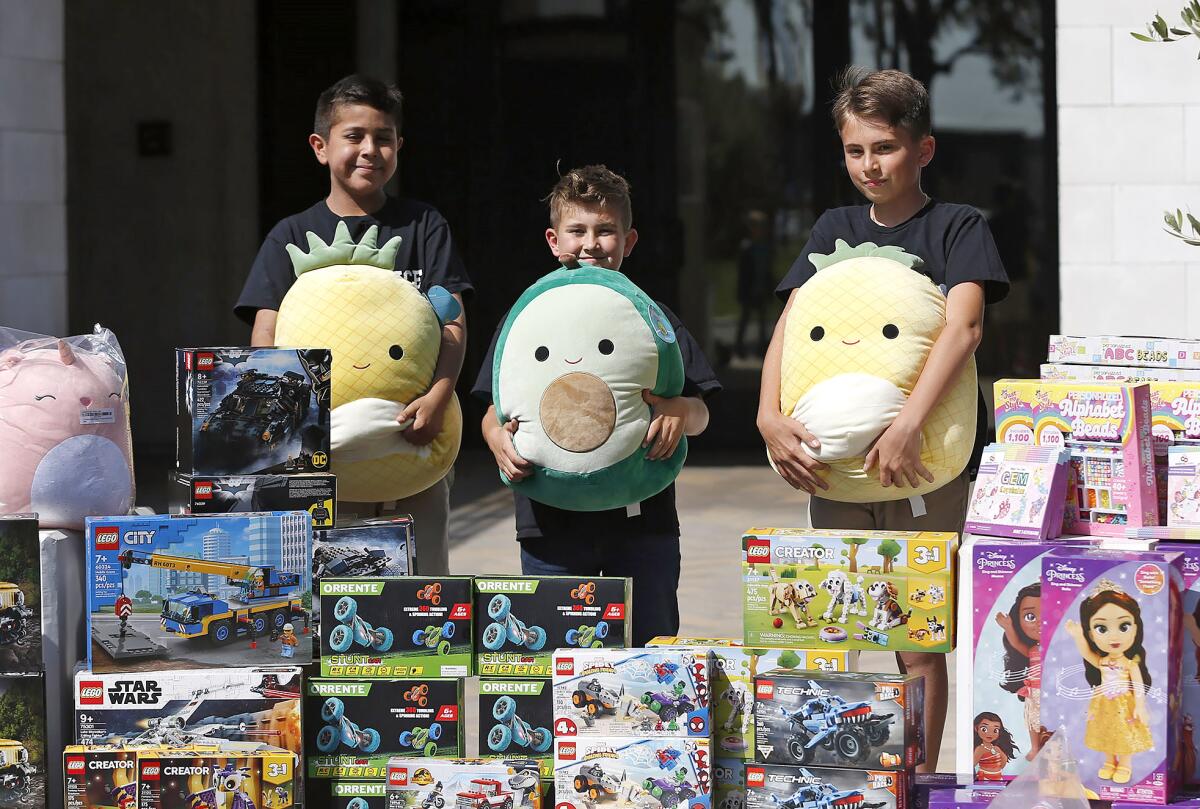 Tim Mustard Jr., Henry Klatt and Anees Mudawar with toys they raised funds for through a school program.