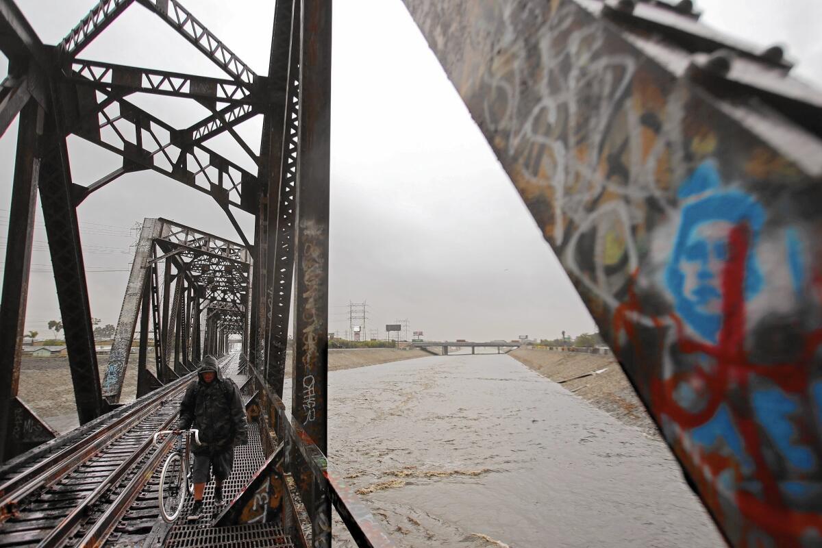 A man walks along an old Union Pacific Bridge as the Los Angeles River flows in South Gate.