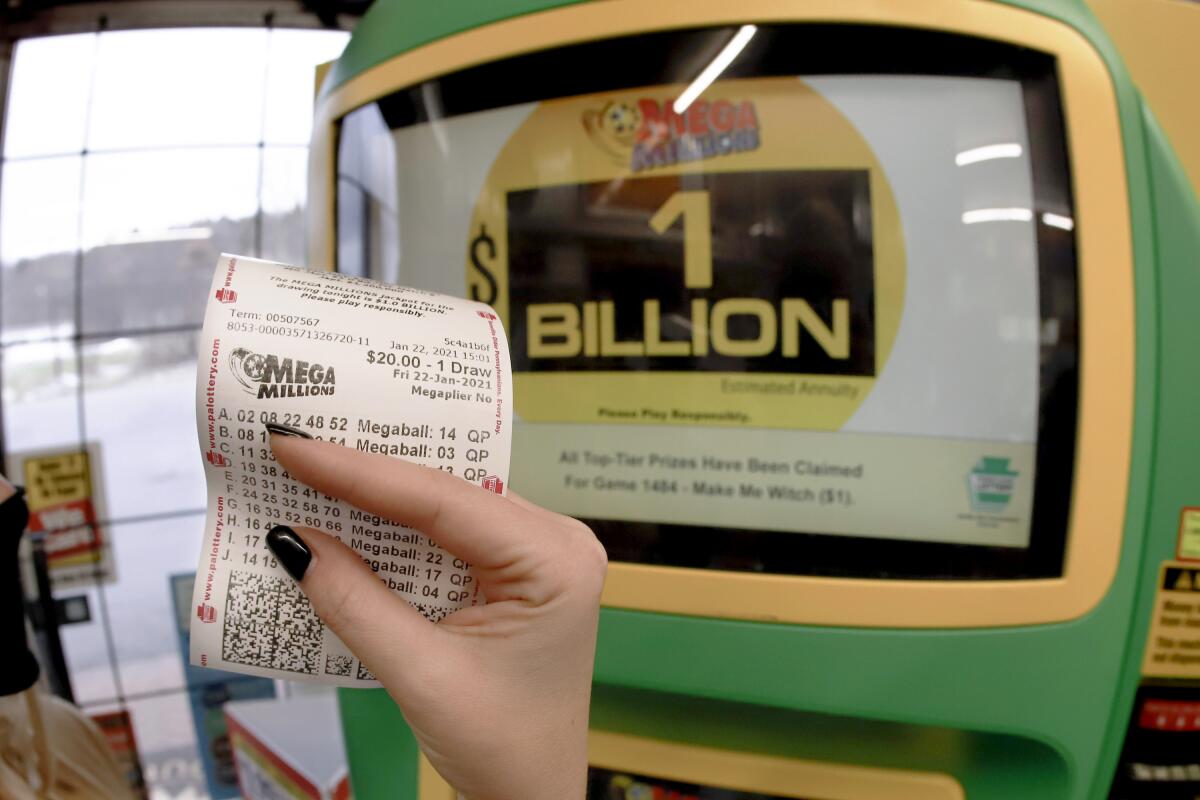 Una mujer muestra un boleto para la lotería Mega Millions