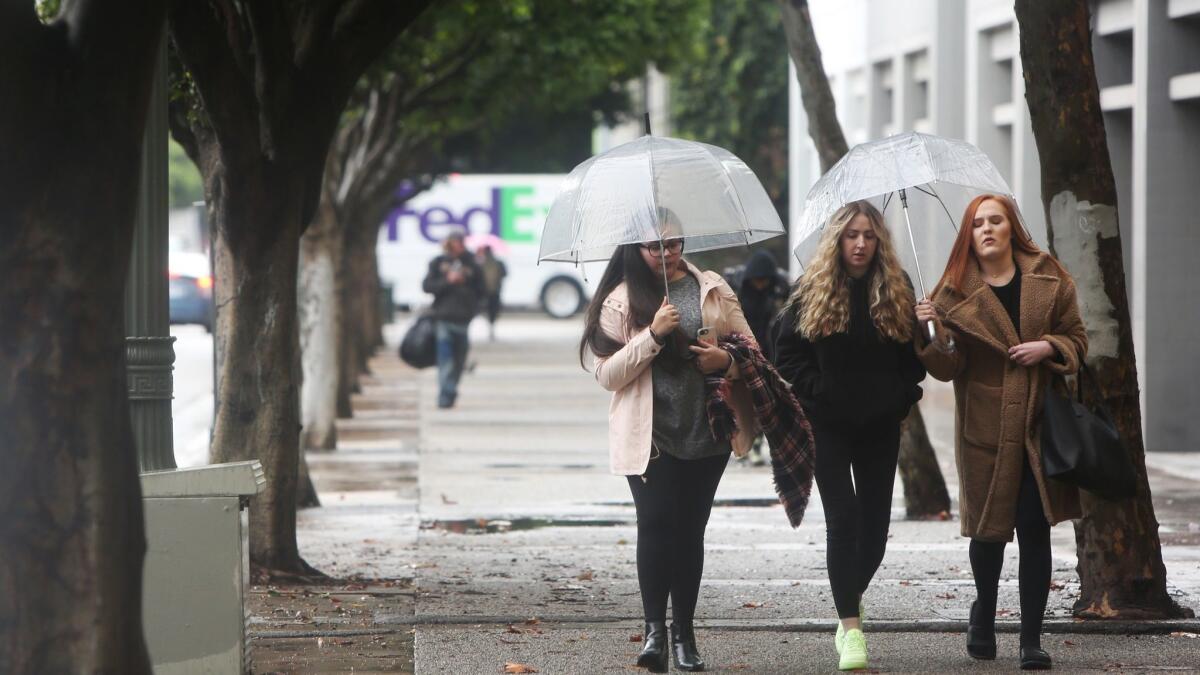 An atmospheric river-fueled storm is expected to hit Los Angeles by Wednesday afternoon. In this file photo, people walk in downtown Los Angeles on a rainy day in early February.