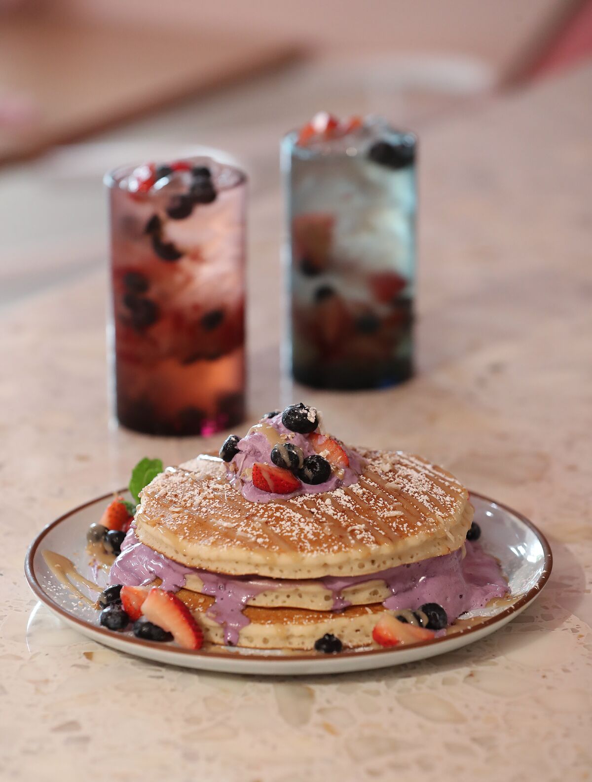 The Ube pancake stack with strawberry and blueberry "refreshers" at the new Breezy restaurant.