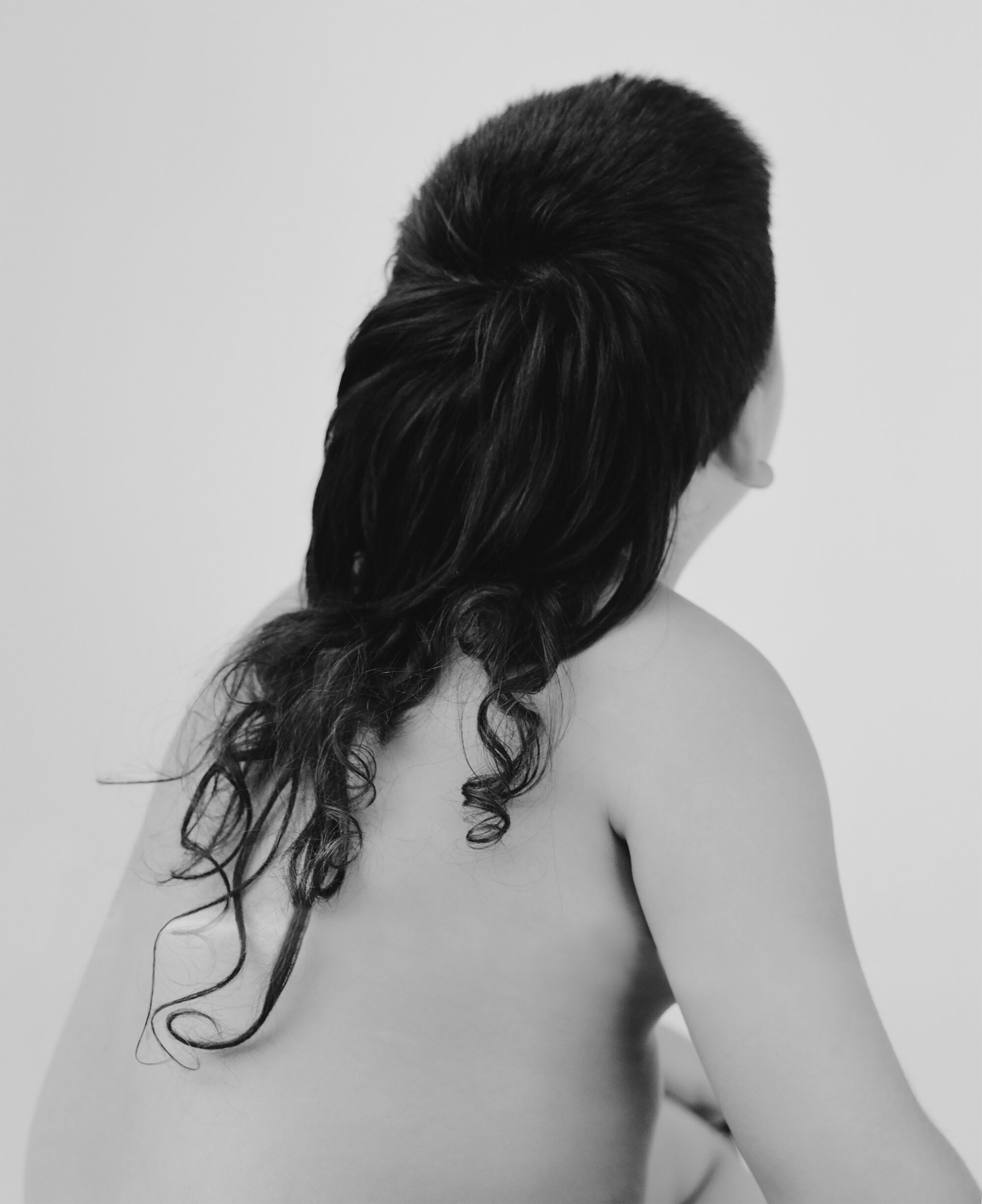 Photo of a long curly mullet seen from behind.