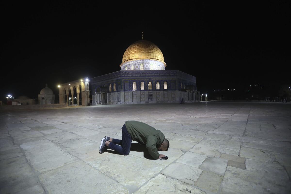 A Muslim man prays next to the Dome of the Rock Mosque in the Al-Aqsa Mosque compound in Jerusalem on Sunday. 