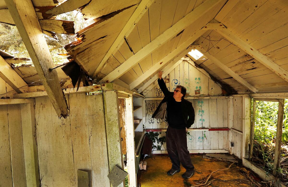 Peter Lewis, youngest son of artist Clayton Lewis, inspects the roof of the guest house at Laird's Landing in Point Reyes National Seashore.