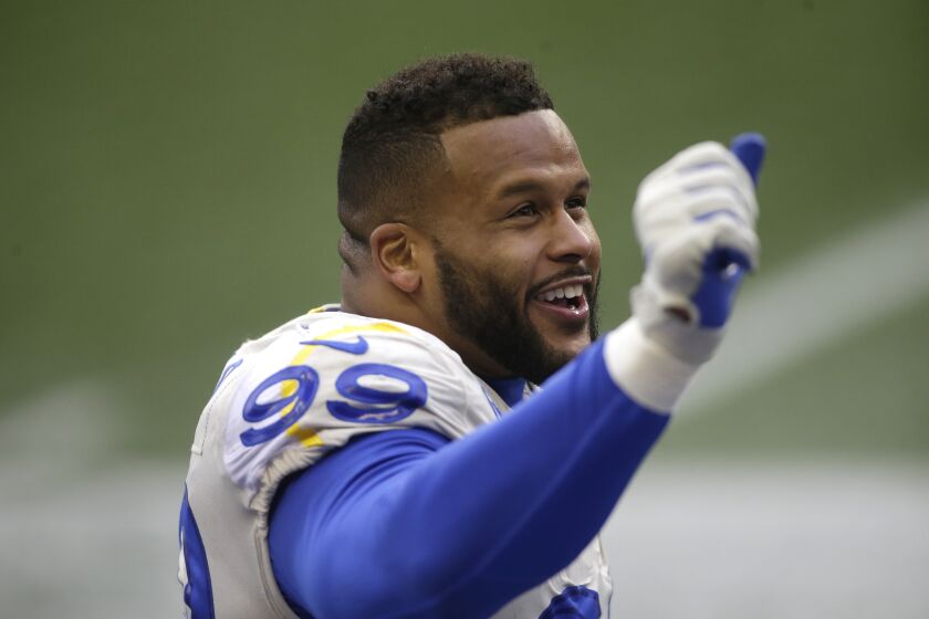 Los Angeles Rams defensive end Aaron Donald smiles as he stands on the sidelines late in the second half of an NFL wild-card playoff football game against the Seattle Seahawks, Saturday, Jan. 9, 2021, in Seattle. The Rams won 30-20. (AP Photo/Scott Eklund)