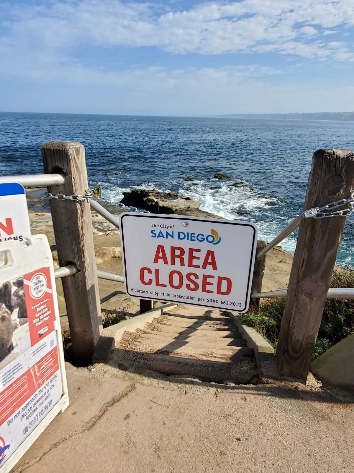 An "area closed" sign blocks off access to the beach