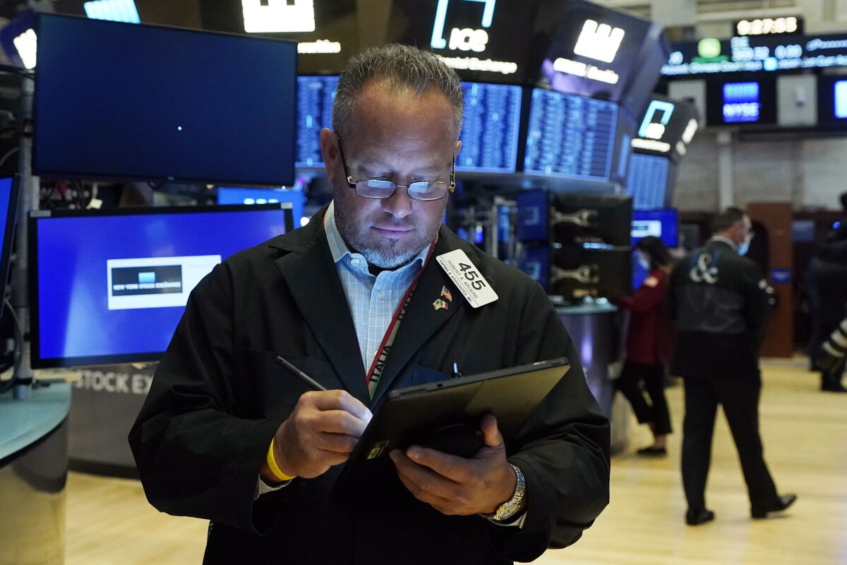 FILE - Trader Robert Arciero works on the floor of the New York Stock Exchange, Aug. 10, 2021. Since inflation began bursting higher last year, big U.S. companies found a simple way to keep making record profits: Pass all those price increases along to their customers. But the formula may be showing signs of reaching its limit, which adds drama to this upcoming earnings reporting season. CEOs are lining up to tell investors how much their businesses earned in the first three months of the year, and they're widely expected to say that earnings growth for the S&P 500 will be the slowest since the end of 2020. (AP Photo/Richard Drew, File)