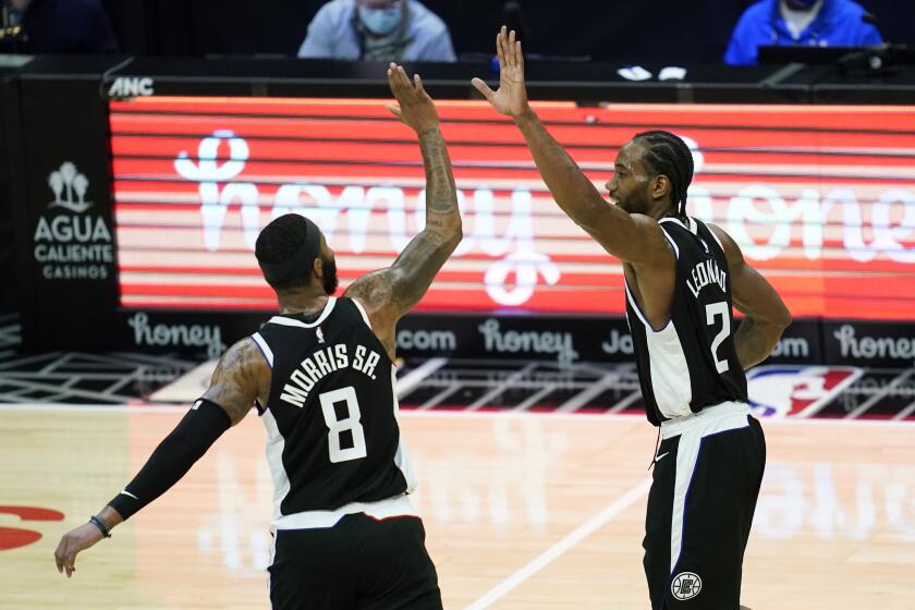 Los Angeles Clippers forwards Marcus Morris Sr. (8) and Kawhi Leonard (2) celebrate a point during the third quarter of an NBA basketball game against the Indiana Pacers, Sunday, Jan. 17, 2021, in Los Angeles. (AP Photo/Ashley Landis)