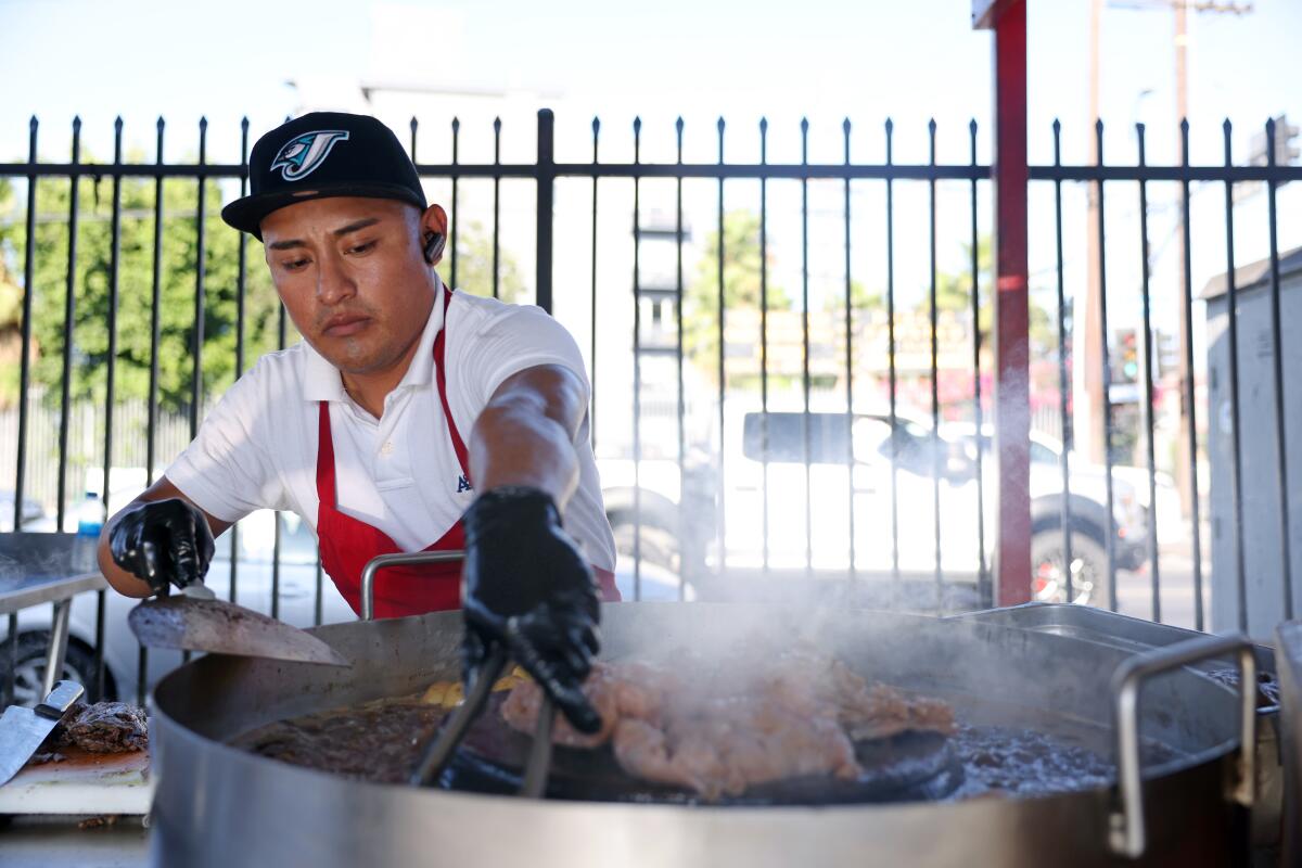 Rafael Gonzalez cooks an assortment of meat for tacos at Avenue 26 Tacos in Little Tokyo. (Dania Maxwell / Los Angeles Times)