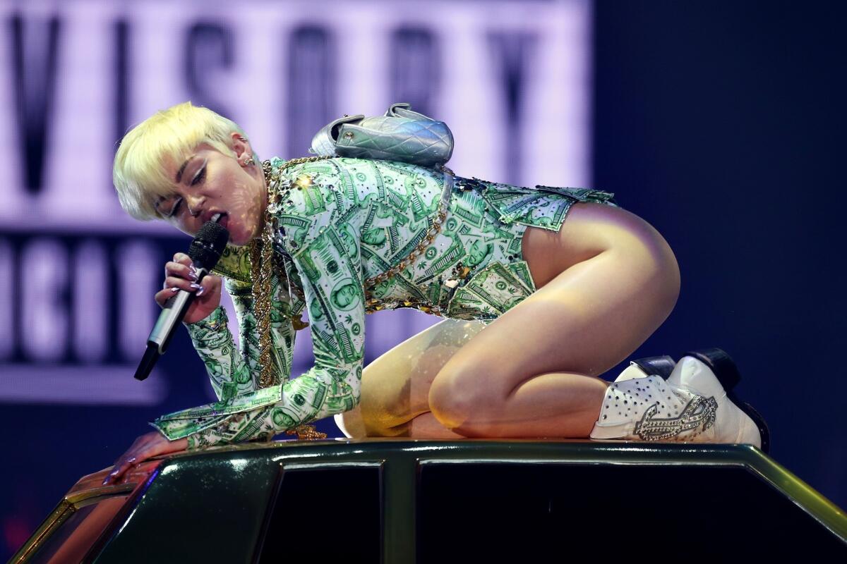 Miley Cyrus, clad in a onesie made of money, performs at London's O2 Arena on May 6.
