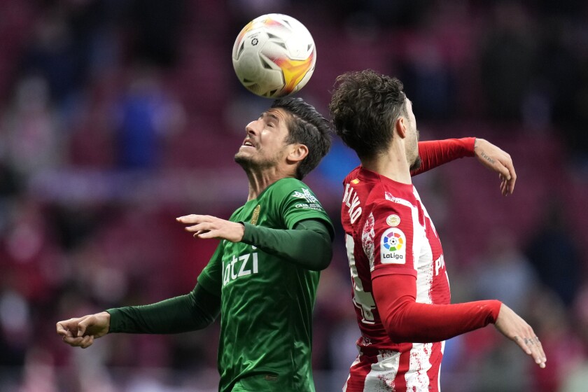 Sergio Escudero, del Granada, peina un balón frente a Sime Vrsaljko, del Atlético de Madrid,