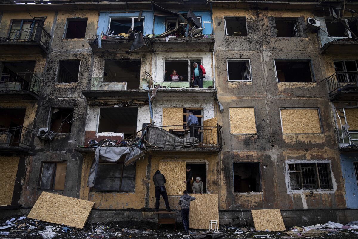 People board up a badly damaged building