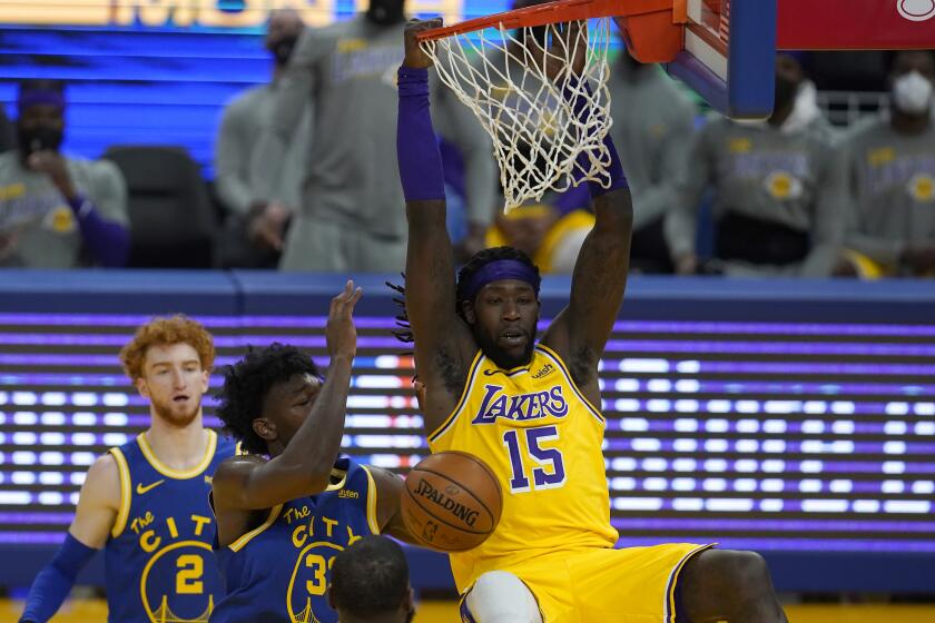 Los Angeles Lakers center Montrezl Harrell (15) dunks next to Golden State Warriors center James Wiseman during the first half of an NBA basketball game in San Francisco, Monday, March 15, 2021. (AP Photo/Jeff Chiu)