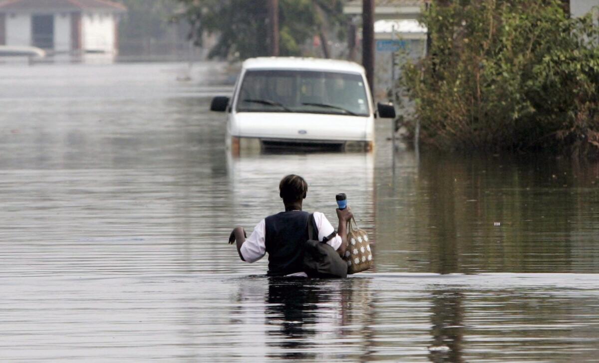 epa04899230 (FILE) A file picture dated 05 September 2005 of a woman returning to her flooded neighbourhood on foot after rescuers had taken her earlier by boat to look for her family in New Orleans, Louisiana, USA. Hurricane Katrina made landfall in Louisiana on 29 August 2005 and devastated New Orleans when the city's levee system failed. More than 1,800 people were killed and some 1.3 million people on the US Gulf Coast lost their homes and livelihoods. It caused an estimated 81 billion US dollars worth of damage, making it the costliest natural disaster the country has ever seen. EPA/SHAWN THEW ** Usable by LA, CT and MoD ONLY **